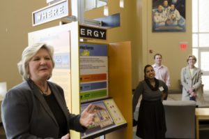 Huntsville, AL - April 15, 2014 - The Nexus of Energy and Space -- U.S. Space and Rocket Center CEO, Dr. Deborah Barnhart, left, unveils a new energy education kiosk created by Nexus Energy Center. The interactive exhibit demonstrates how the buildings we occupy consume 40% of America's energy and offers advice for reducing energy bills and climate change. Nexus Energy Center director Ruchi Singhal and AlabamaWISE program manager Daniel Tait look on during the event during an Energy Huntsville meeting Tuesday. (Photo by Brian Brainerd)